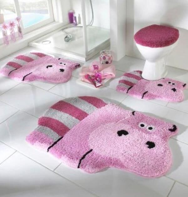 bathroom with pink rugs, toilet and sink in the middle is decorated like a cartoon character