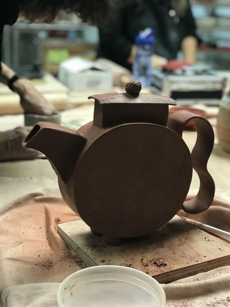 a brown teapot sitting on top of a wooden table