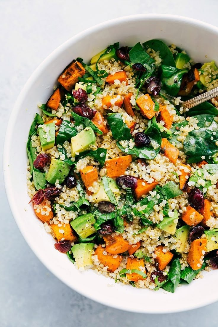 a white bowl filled with vegetables and grains