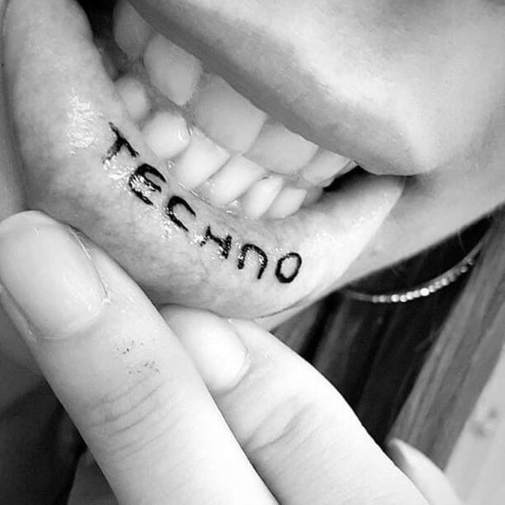 a woman holding up her teeth with the word te amo written on it