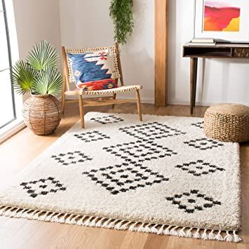 a living room with a rug, chair and potted plant