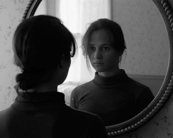 a woman looking at herself in the mirror