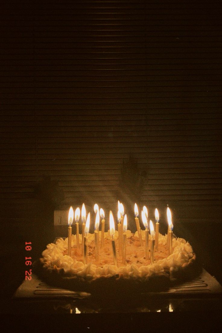 a birthday cake with many lit candles on it