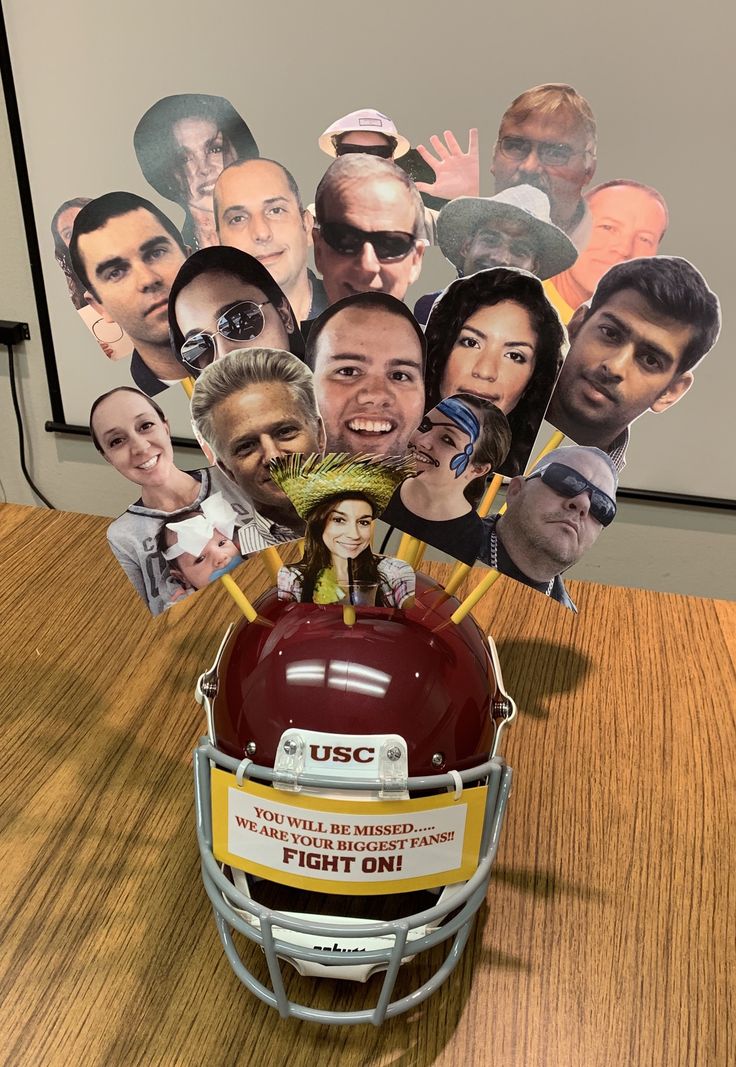 a football helmet with many pictures of people on the front and side, sitting on top of a wooden table