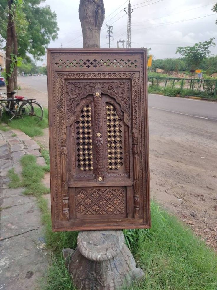 an old wooden door sitting on the side of a road