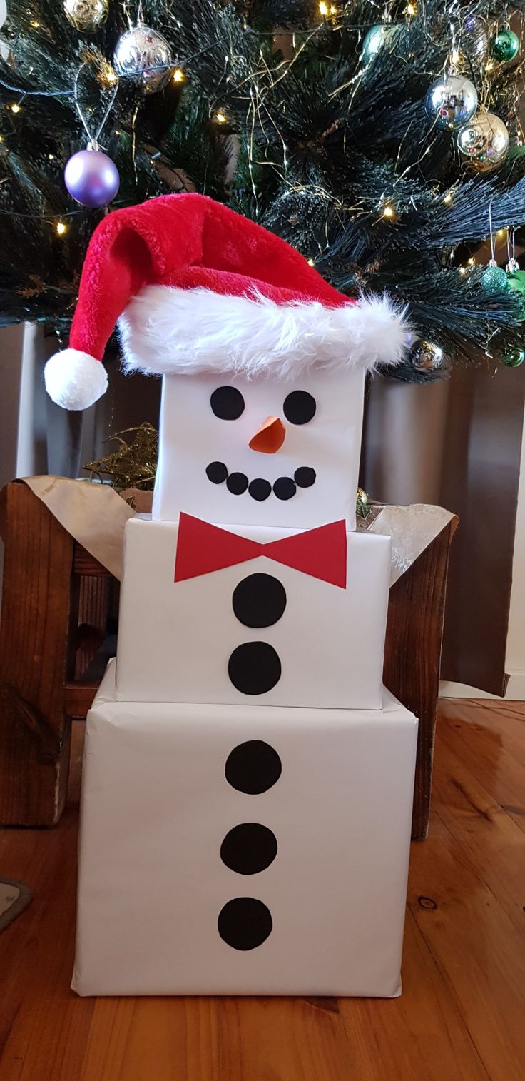 a cardboard box with a snowman on it and a christmas tree in the background