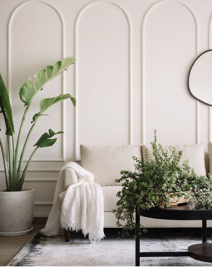 a living room filled with furniture and plants