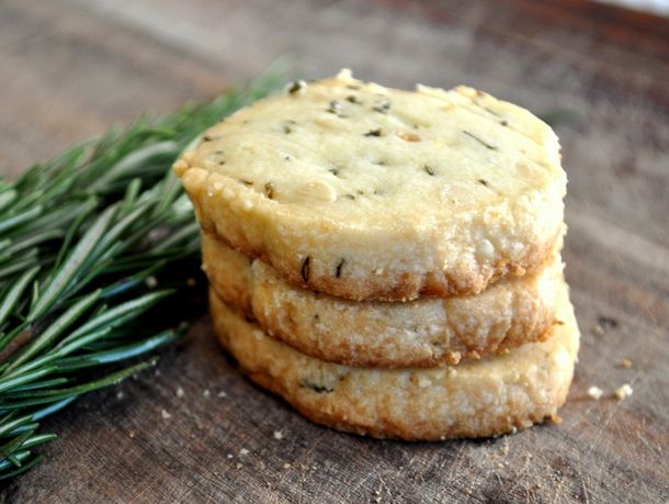 three cookies stacked on top of each other with rosemary sprigs in the background