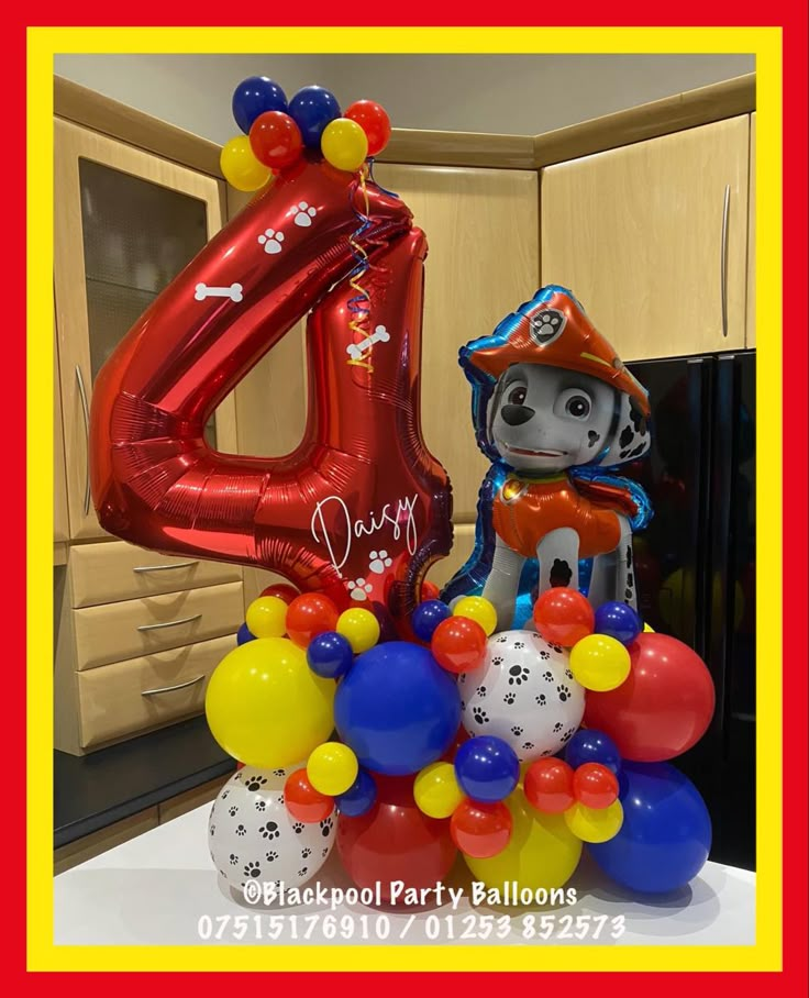 a birthday decoration with balloons in the shape of a fireman's hat and number four