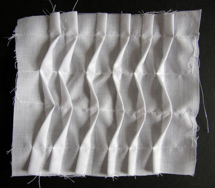 the white fabric has been stitched together to make an interesting piece of art work