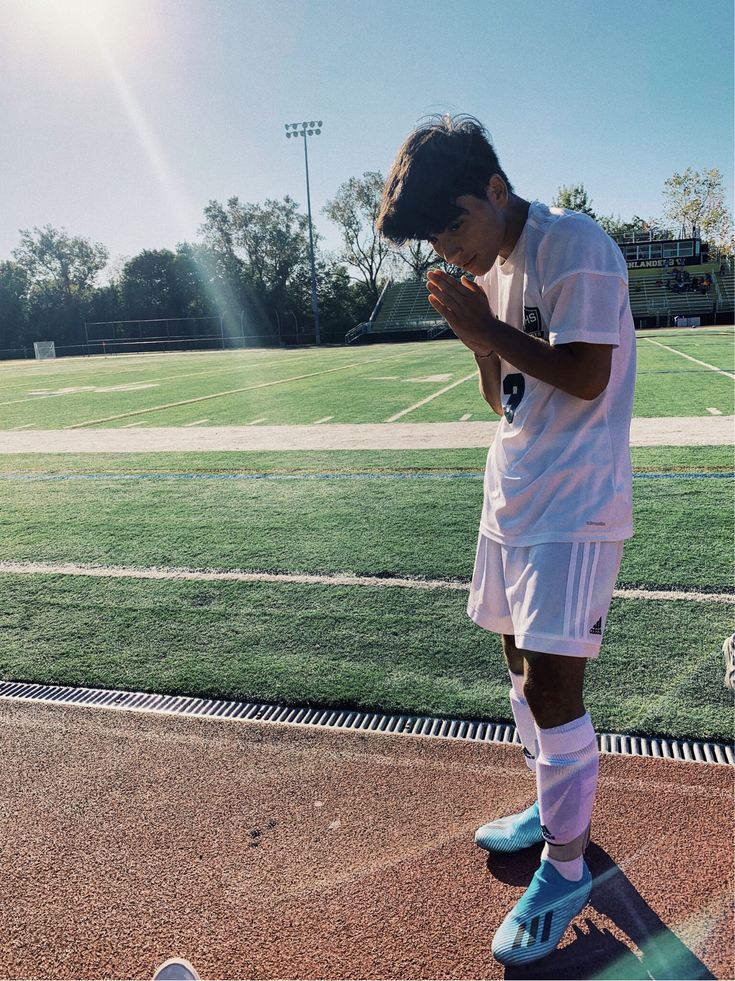 a young man standing on top of a soccer field