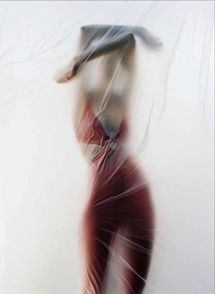 a blurry photo of a woman in a red dress with her hair flying through the air