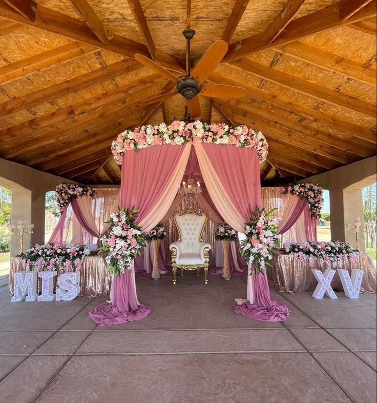 an outdoor wedding venue decorated with pink and white flowers