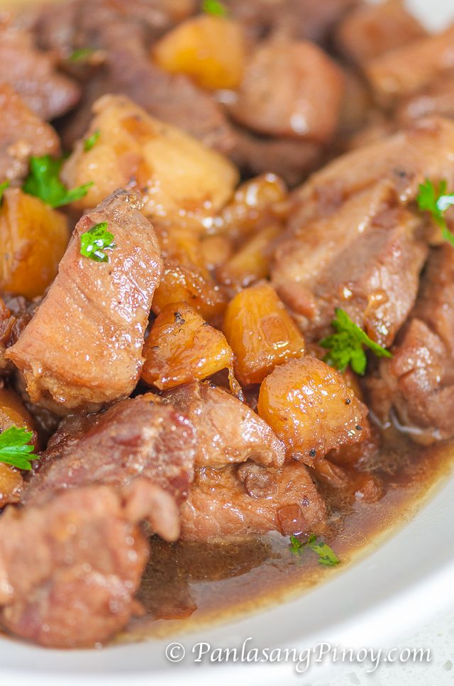 a white plate topped with meat and potatoes