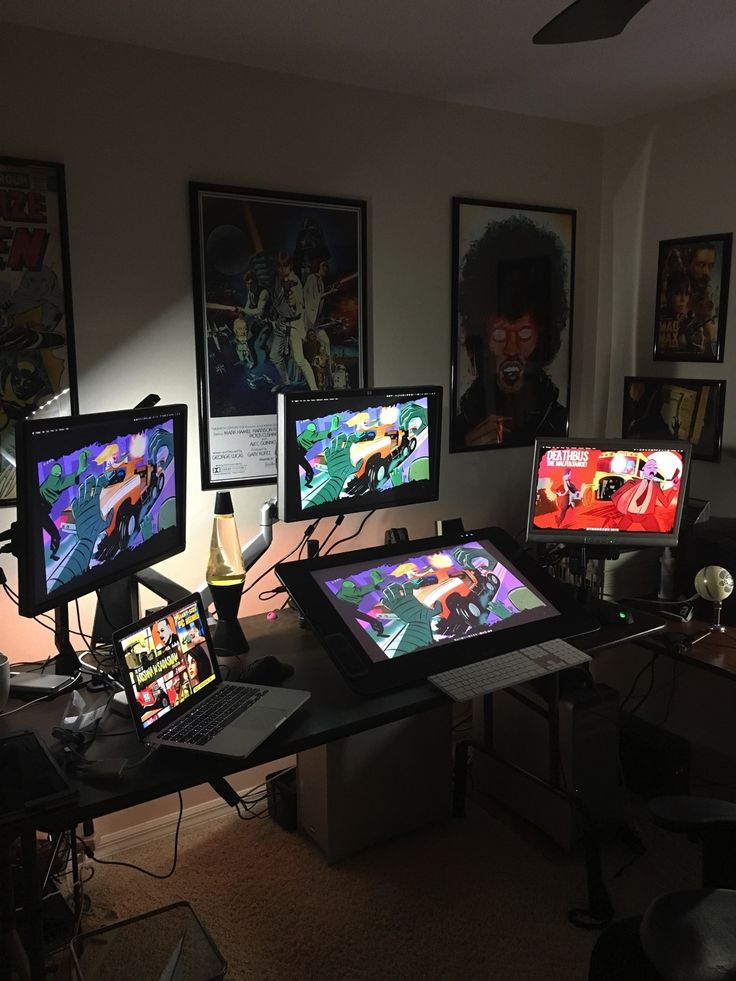 a room with multiple computer monitors and pictures on the wall above them, all displaying different video games