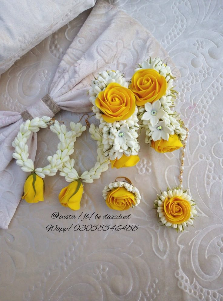 yellow and white flowers are arranged on a bed