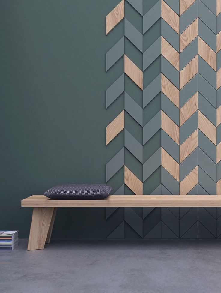 a wooden bench sitting in front of a wall with chevron wood panels on it