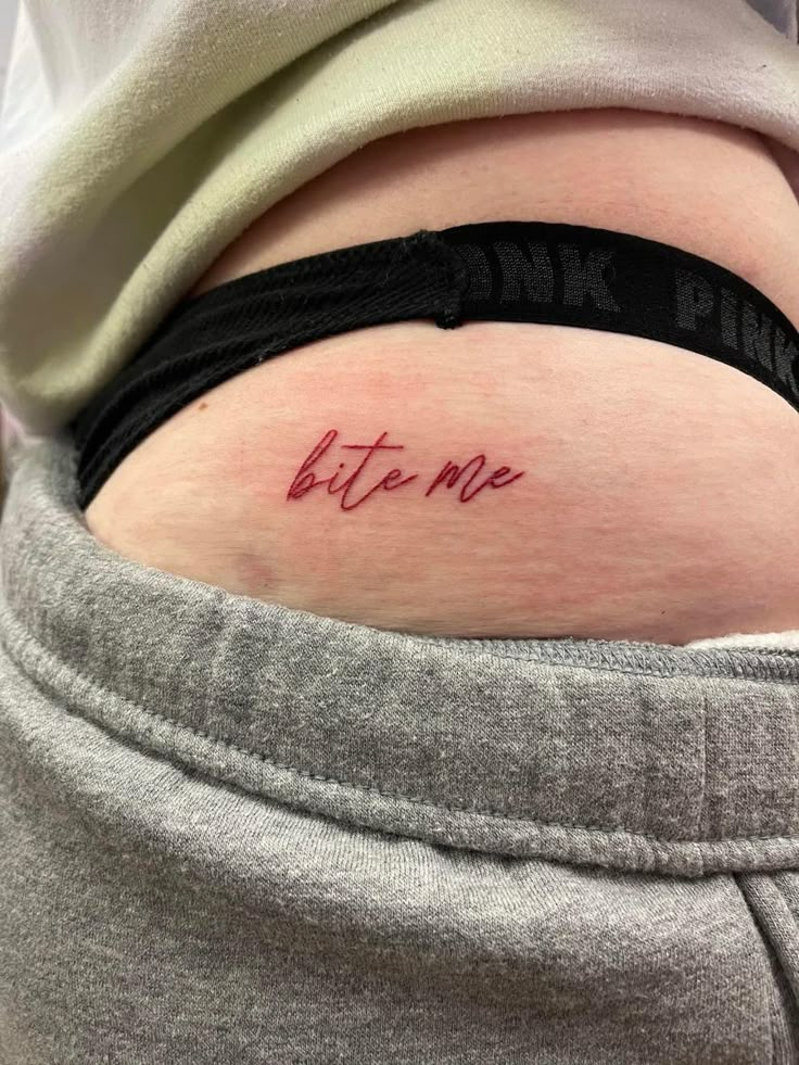 a woman with a tattoo on her stomach saying, bite me