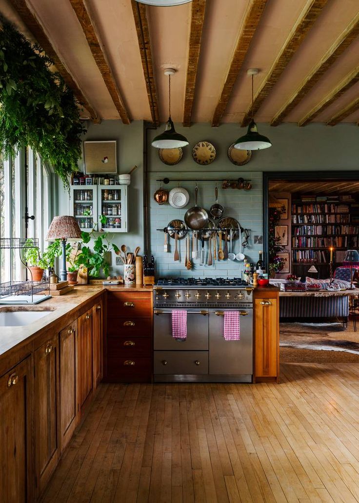 a kitchen with wooden floors and lots of hanging pots