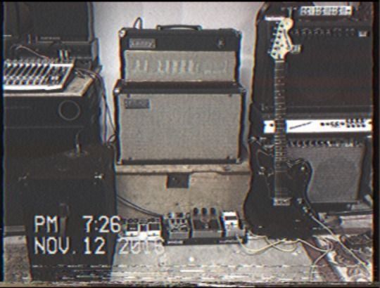 some guitars and amps in a room