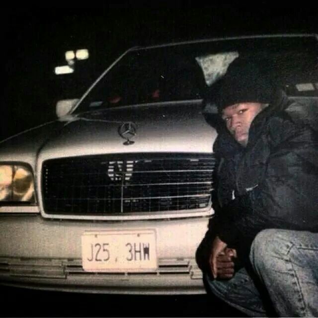 a man kneeling down next to a parked car