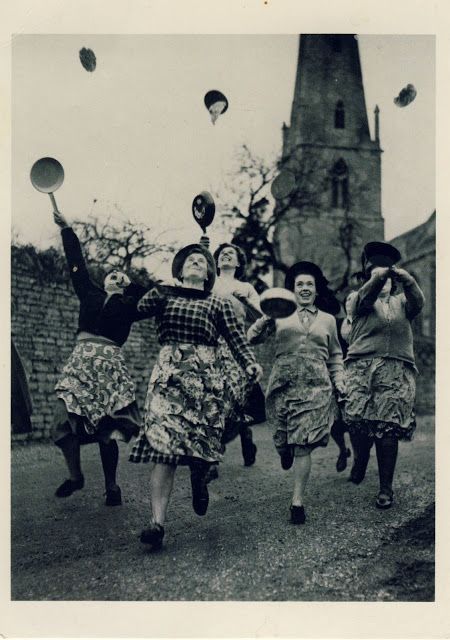 an old black and white photo of women in dresses running with hats on their heads