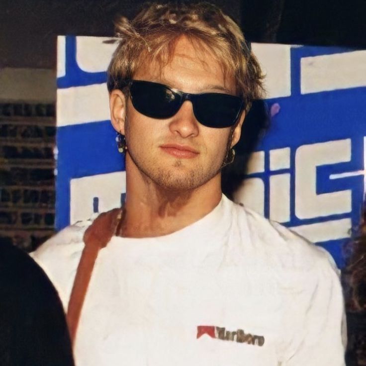 a man with sunglasses and a white shirt