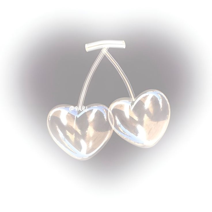 two clear heart shaped earrings hanging from a metal hook on a white background with light reflection