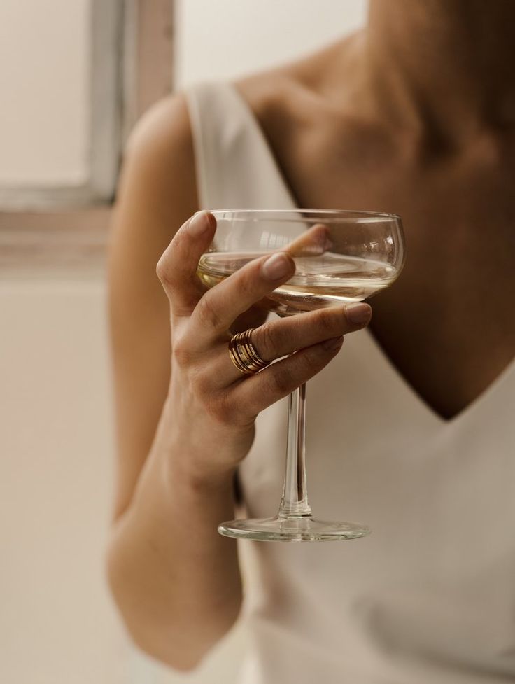 a woman holding a wine glass in her hand