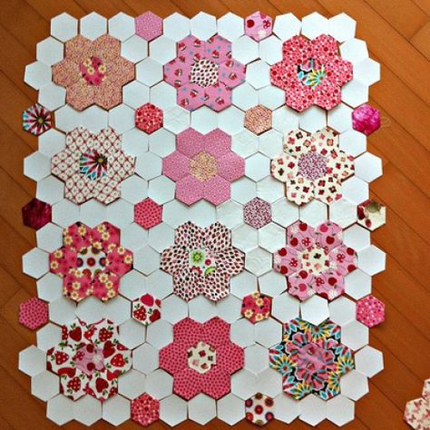 an array of hexagons are arranged on a wooden floor with pink and red flowers