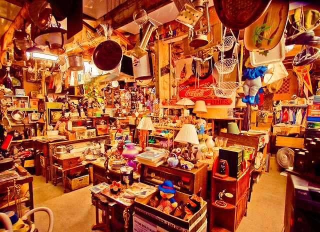 a room filled with lots of different types of items and lamps hanging from the ceiling