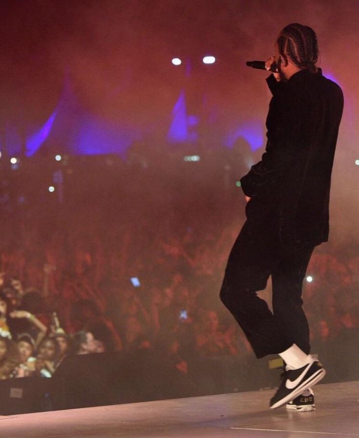 a man standing on top of a stage holding a microphone