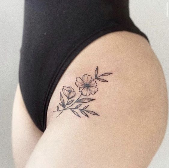 a woman's thigh with a flower tattoo on it