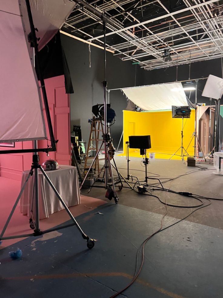 an empty photo studio with lights and lighting equipment on the floor in front of it