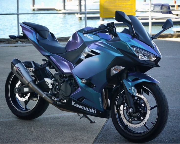 a blue motorcycle parked next to the water