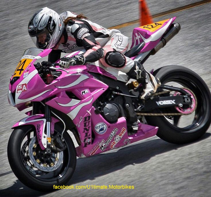 a person riding a pink motorcycle on a race track