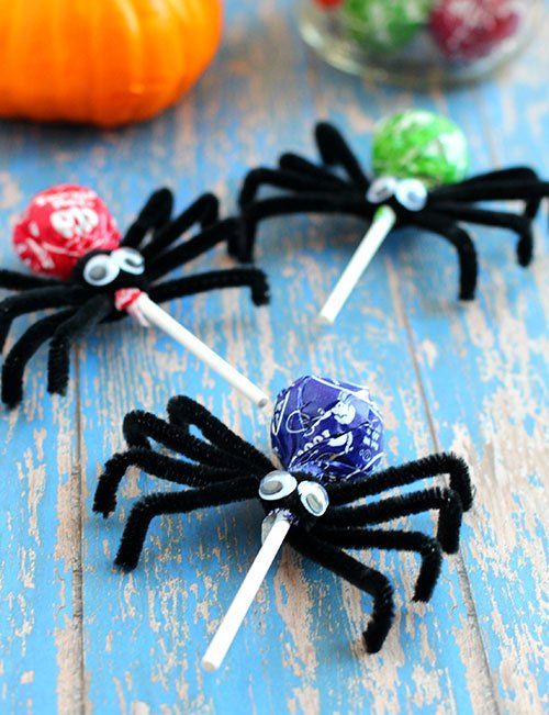 three spider lollipops sitting on top of each other next to some candy