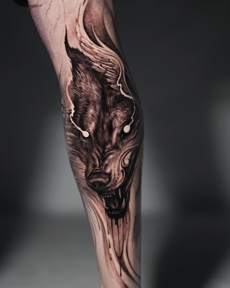 a man's leg with a wolf tattoo on it