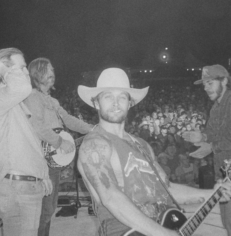 black and white photograph of two men with guitars in front of an audience at a concert