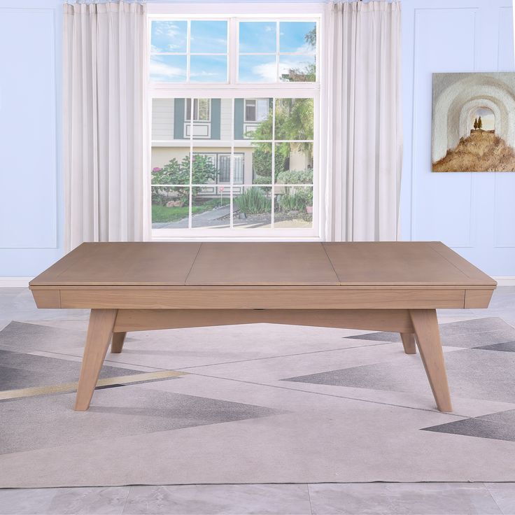 a wooden coffee table in front of a window