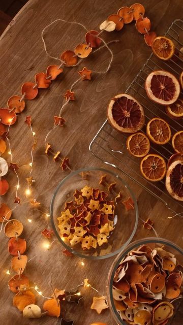 oranges and dried fruit are arranged on a table with string lights around them for decoration