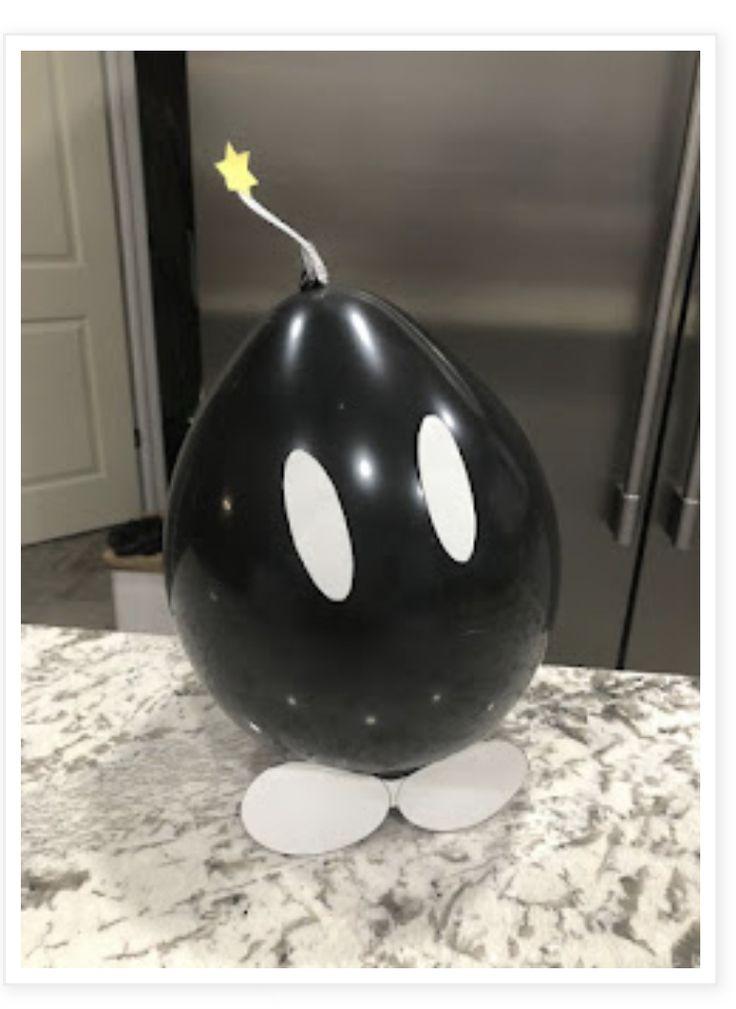 a large black balloon with white dots and a yellow star on the tip sitting on top of a counter