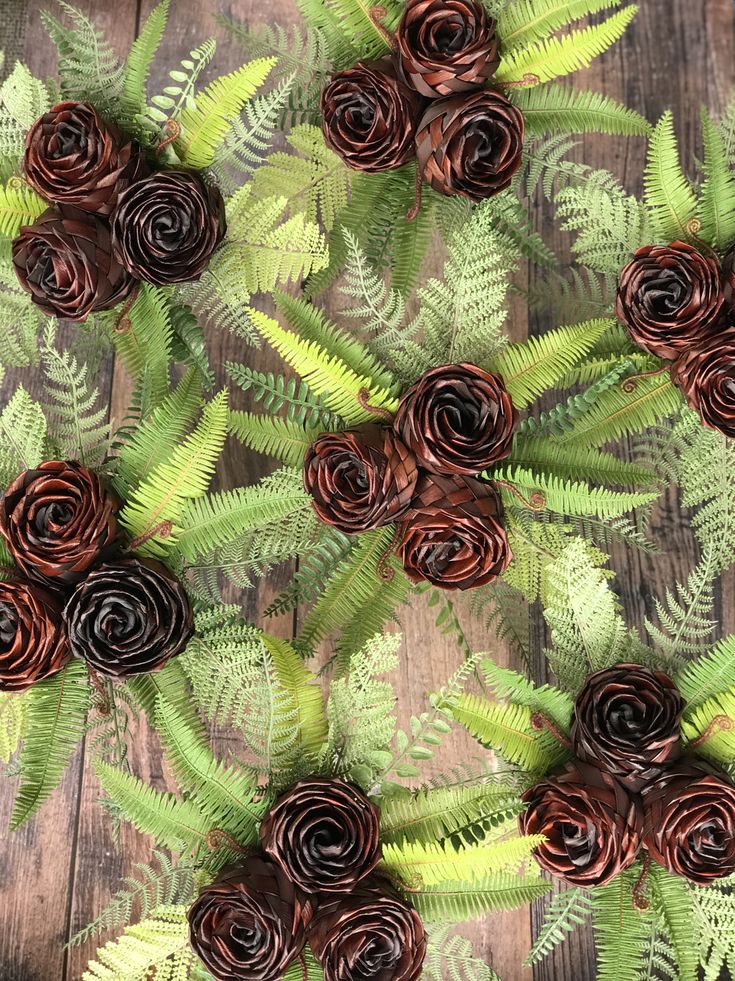 some brown flowers and green leaves on a wooden surface