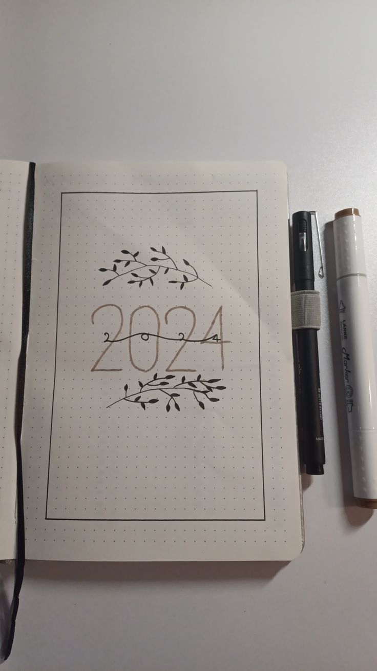 an open notebook with the year 1994 written on it next to a pen and marker