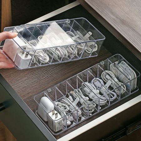 two clear plastic containers filled with electrical cords and plugs on top of a wooden table