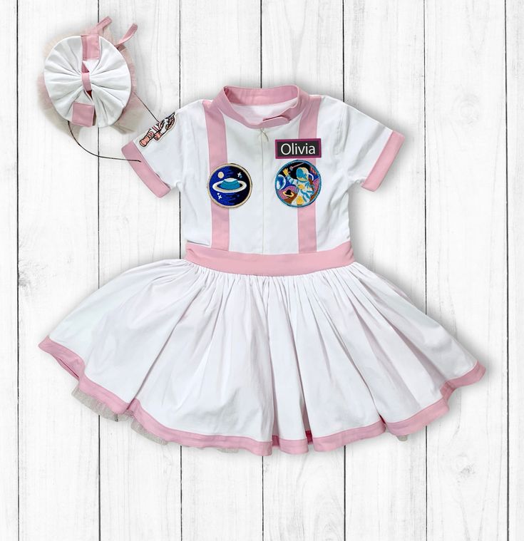 - - Pink Dress Space Suit Space Theme Birthday Party-Astronaut Costume-Space Baby Shower-Halloween Costumes Nursery - - Names are embroidery! - - Costume includes the patches! - - Made to order. - - Our costumes are entirely handmade. - - Size: Astronaut Dress 0-10  age  - - SHIPPING TIME: 3-5 days - UNITED STATES 3-5 days - CANADA 4-8 days - AUSTRALIA 1-3 days - EUROPEAN UNION 1-3 days - UNITED KINGDOM 1-3 days - EUROPE NON-EU 4-10 days - INTERNATIONAL - - Each element is unique because it is h Cute Fitted Costumes For Costume Party, Fitted Cute Costume For Costume Party, Playful Fitted Set For Dress-up, Playful Fitted Dress-up Sets, Fitted Character Print Costume, Playful Fitted Sets With Character Print, Fitted Character Print Costume For Costume Party, White Themed Party Costumes, White Cotton Costumes For Costume Party