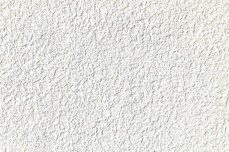 a white stucco wall with small cracks in it