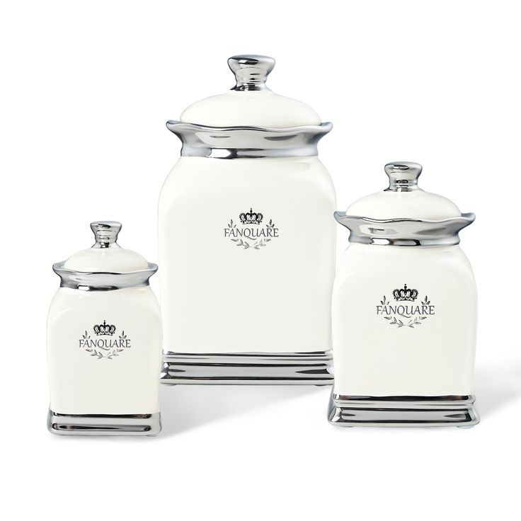 three white canisters with metal lids and silver trim on the sides, one has a