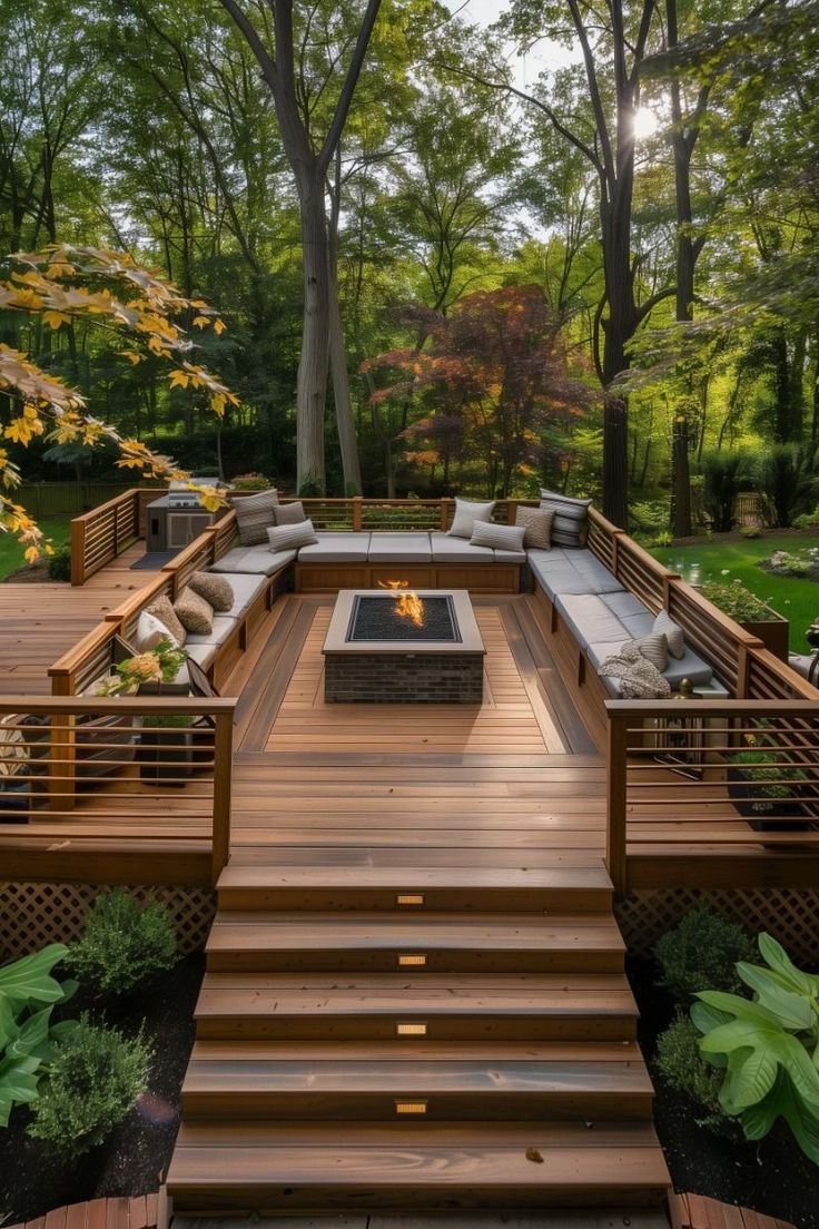 a wooden deck with seating and fire pit surrounded by trees in the middle of it