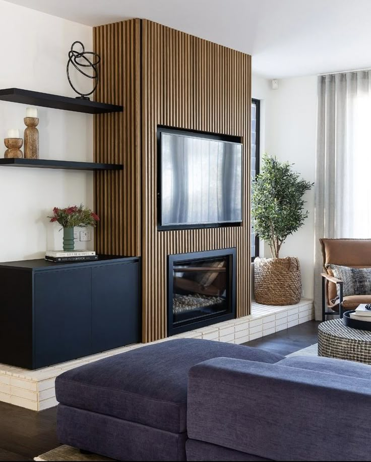 a living room filled with furniture and a flat screen tv mounted on a wall above a fireplace